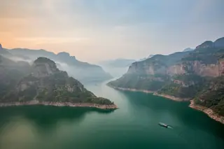 Jiyuan, China — the emerald Yellow River Three Gorges reservoir winding between the layered Wangwu and Taihang mountains