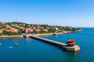 Qingdao, China — Zhanqiao Pier and the red-roofed Huilan Pavilion beside the seaside old town